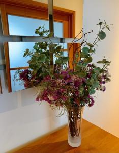 wazon wypełniony kwiatami na stole w obiekcie Yellow Five Apartment w mieście Ponta Delgada