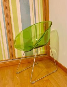 a green chair sitting in front of a window at Yellow Five Apartment in Ponta Delgada