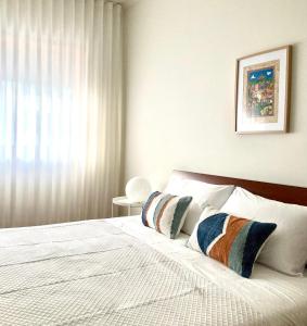 a bedroom with a bed with two pillows on it at Yellow Five Apartment in Ponta Delgada