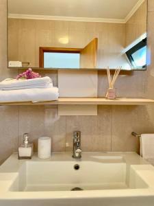 Yellow Five Apartment في بونتا ديلغادا: حمام مع حوض أبيض ومرآة