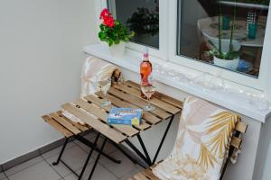 einen Tisch mit zwei Gläsern und einer Flasche Alkohol in der Unterkunft Kamilla Apartman in Makó