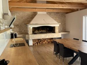 cocina con chimenea y mesa con sillas en Luxury Villa HARBOR, en Bibinje