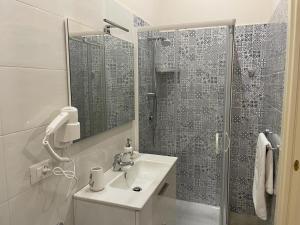 een witte badkamer met een wastafel en een douche bij Nicole House in Reggio di Calabria