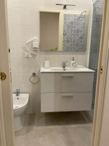 een badkamer met een wastafel, een toilet en een spiegel bij Nicole House in Reggio di Calabria