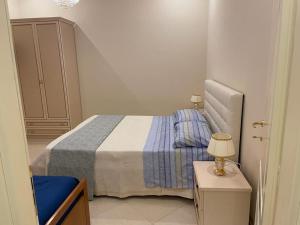 een kleine slaapkamer met een bed en een tafel met een lamp bij Nicole House in Reggio di Calabria