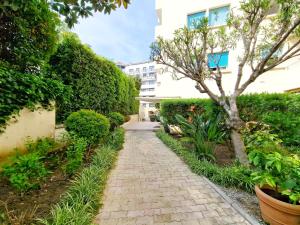un camino de ladrillo en un jardín con un árbol en Cannes Appartement Palais Festivals, en Cannes