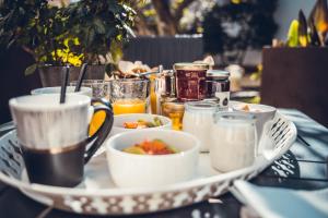 una mesa con un plato de comida y bebida en Chambre d'hôte romantique avec SPA privatif domaine les nuits envôutées - Vézénobres, en Vézénobres