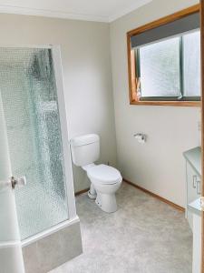 a bathroom with a toilet and a window at Vacation on Nation in Inverloch