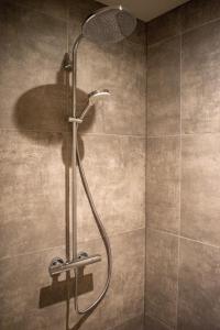 een douche met een douchekop in de badkamer bij Hotel B&B Buiten Loon in Loon op Zand