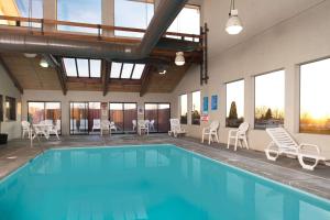 a large swimming pool with chairs and tables in a building at Super 8 by Wyndham Walla Walla in Walla Walla