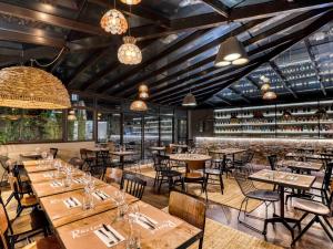un restaurante con mesas y sillas y un bar en Mercure Pont d’Avignon Centre en Aviñón