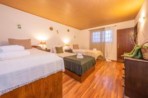 a hotel room with two beds and a television at Roteiro dos Moinhos in Palmela