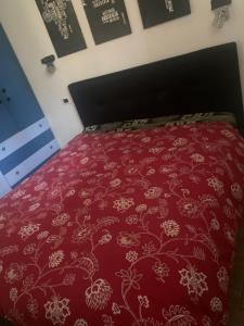 sypialnia z łóżkiem z czerwoną narzutą w obiekcie Guest House Persico w mieście Desenzano del Garda