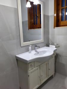 y baño con lavabo blanco y espejo. en Villino Melina, en Santa Maria al Bagno