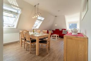 - une salle à manger et un salon avec une table et des chaises dans l'établissement Haus Eva Wohnung 2, à Wyk auf Föhr