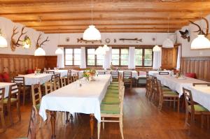 uma sala de jantar com mesas e cadeiras brancas em Bräugasthof Hallstatt em Hallstatt