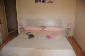 a large white bed with towels and two pink lamps at La Marinella in Tonfano