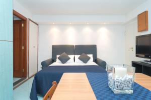 een slaapkamer met een bed met een tafel en een televisie bij Plebiscito Apartment in Napels