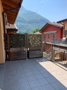 d'un balcon avec une porte en bois offrant une vue sur la montagne. dans l'établissement Appartamento IRIS, à Spinone Al Lago
