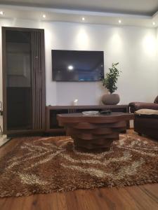 sala de estar con sofá y TV en la pared en I&G APARTMENTS, en Kotor