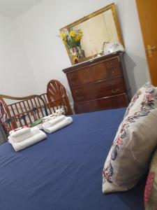 1 dormitorio con 1 cama azul y 2 toallas en Casa Holiday, en Caccamo