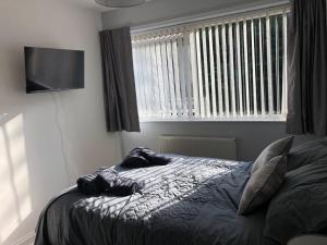 a bedroom with a bed and a flat screen tv at Ainsdale Gardens in Birmingham