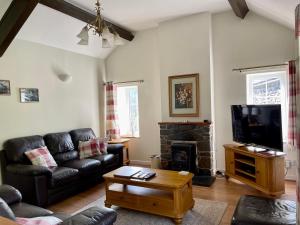 a living room with a couch and a fireplace at Cosy 2 Bedroom Cottage in Betws y Coed, Snowdonia in Betws-y-coed