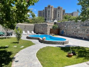 uma piscina num quintal com edifícios ao fundo em Cozy Apartment With The Best Patio and Swimming pool em Yerevan