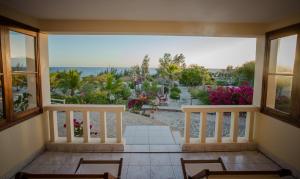 a room with a balcony with a view of the ocean at Hôtel La Mira de Madiorano in Ambolomailaka