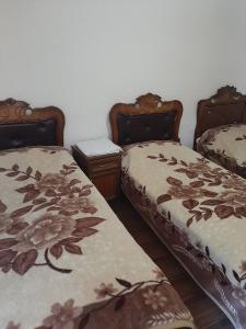 a room with two beds and a table at NarVar Hotel in Goris