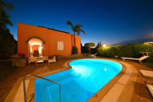 a swimming pool in front of a house at night at Villa Stefania in Ischia