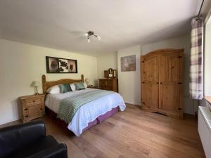 a bedroom with a bed and a chair and a window at Cosy 2 Bedroom Cottage in Betws y Coed, Snowdonia in Betws-y-coed