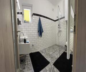 ein weißes Bad mit einem Waschbecken und einer Dusche in der Unterkunft Péter Dock Boutique Villa Keszthely in Keszthely