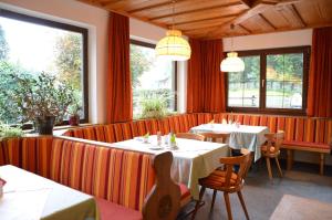 a restaurant with tables and chairs and windows at Pension Hirlatz in Hallstatt