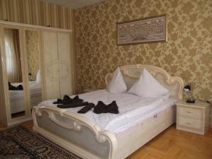 a bedroom with a white bed with black shoes on it at Ametist in Mukacheve