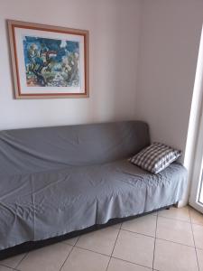 un sofá en una habitación con una foto en la pared en Apartman BoloB en Baška