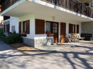 a small house with a table and a balcony at CASA BRENZ in Madonna di Campiglio