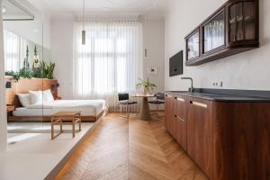 a bedroom with a bed and a kitchen with a table at Wyspa 12 in Poznań