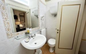 a bathroom with a sink, toilet and mirror at Hotel San Michele in Cortona