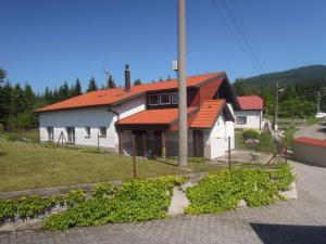 a house with an orange roof on a street at Pension Úsvit in Podkopná Lhota