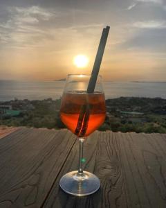 a glass of wine sitting on a table with the sunset at Il Chiostro in Massa Lubrense