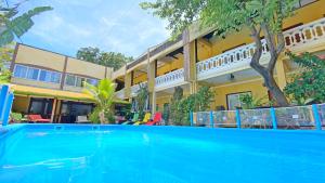 a swimming pool in front of a house at Hôtel Restaurant Coco Lodge Majunga in Mahajanga
