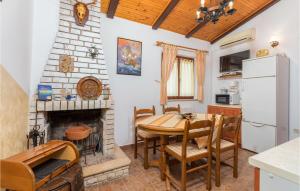 a kitchen and dining room with a table and a fireplace at Pet Friendly Home In Fazana With Kitchen in Fažana