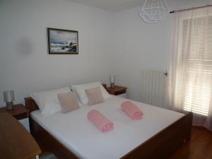 Un dormitorio con una cama con almohadas rosas. en Tina, en Poreč