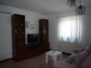 sala de estar con sofá y TV en Tina, en Poreč