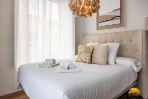 - une chambre avec un lit blanc, des serviettes et un lustre dans l'établissement Carpenter's Home by Cadiz Time, à Cadix