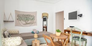a living room with a couch and a table and chairs at A Calata Rooms in Noto