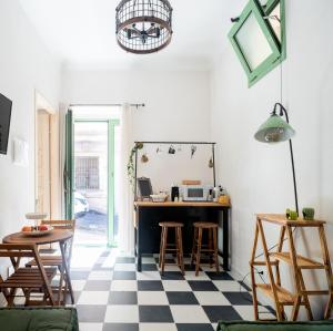 a room with a desk and chairs and a checkerboard floor at A Calata Rooms in Noto