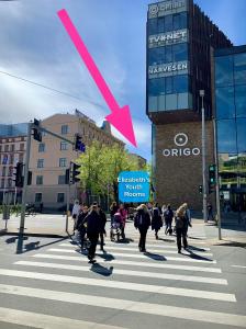 a group of people crossing a street at a crosswalk at Elizabeth's YH Rooms in Rīga