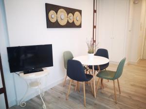 a dining room with a table and chairs and a television at Beautiful Apartment in the heart of seville in Seville